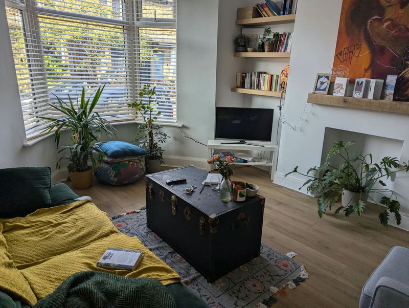 Lounge with a bay window, alcove shelving, a fireplace recess and a wooden floor