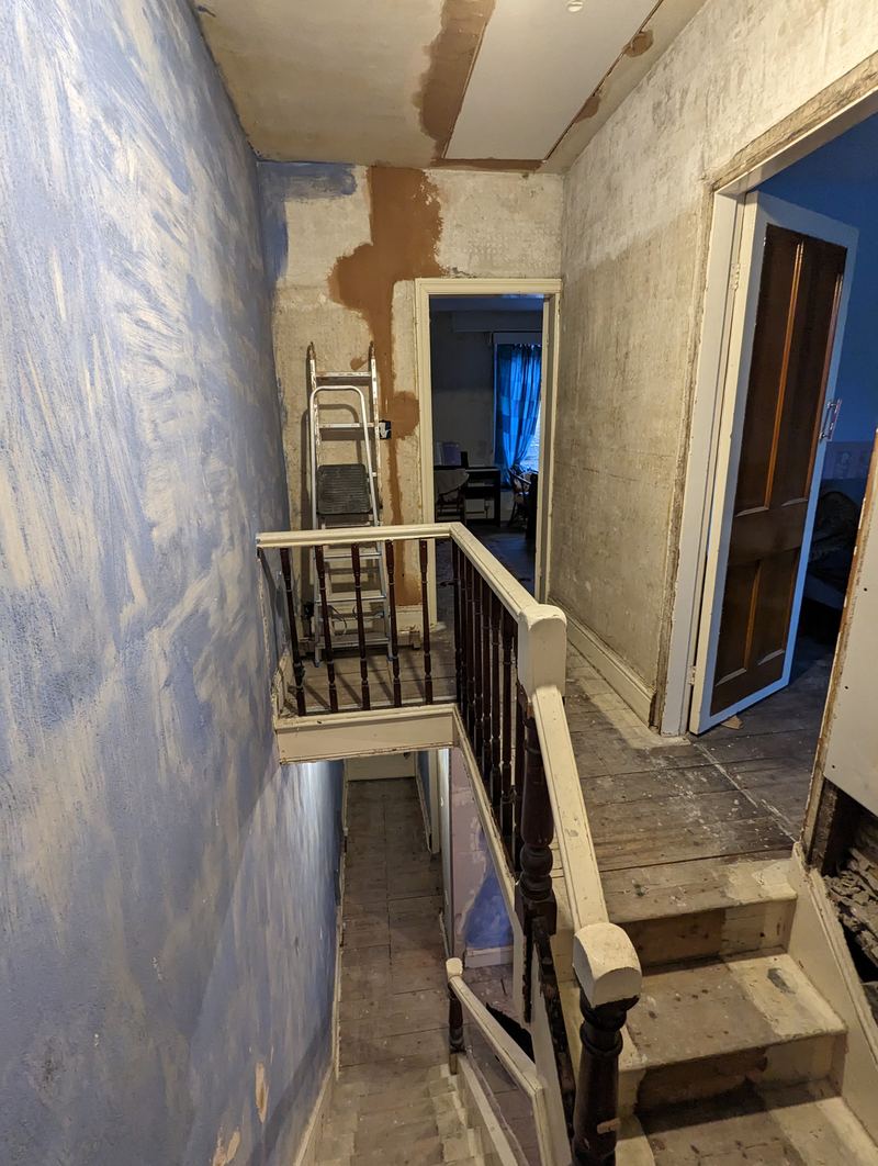 The landing and staircase mid-renovation, with bare floorboards