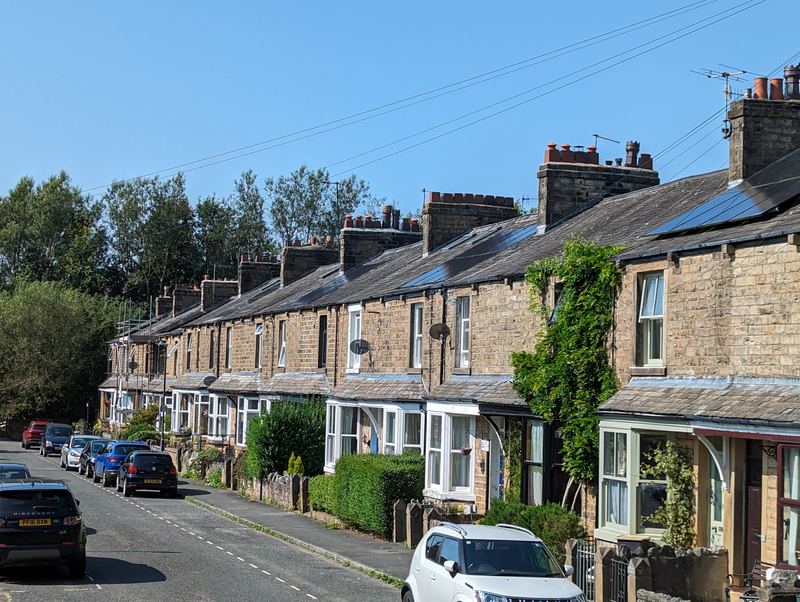 Stone terraced houses along Cromwell Road, Lancaster, on a clear day